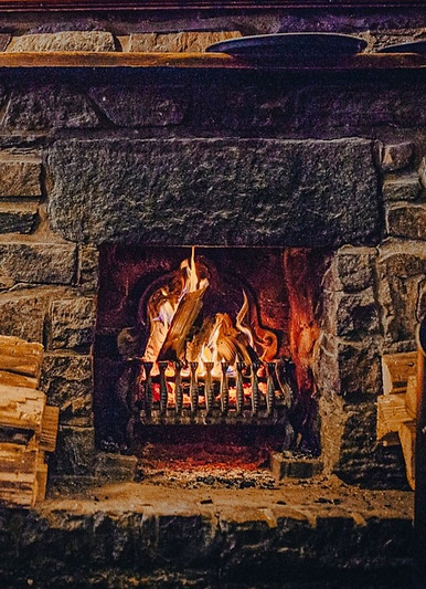 Old stone fireplace with roaring fire in the restaurant at The App AvaiBook Scotland